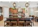 Gourmet kitchen island features dark countertops, a stainless sink, and seating beneath modern pendant lighting at 5305 Sagecrest Dr, Lithia, FL 33547
