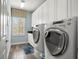 Bright laundry room complete with a large window, washer/dryer, and plenty of cabinet space at 5305 Sagecrest Dr, Lithia, FL 33547