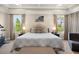 Well-lit main bedroom with tray ceilings, large windows, and seating area at 5305 Sagecrest Dr, Lithia, FL 33547
