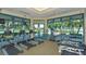 Well-equipped gym featuring treadmills, elliptical machine, weights, and ample natural light at 6504 Virginia Xing, University Park, FL 34201