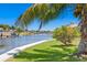A waterfront home with a lush green lawn, mature trees, and boat dock on a sunny day at 708 Islebay Dr, Apollo Beach, FL 33572