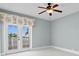 Bedroom boasting a ceiling fan, french doors, and plenty of natural light with balcony access at 708 Islebay Dr, Apollo Beach, FL 33572