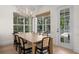 Light-filled dining room featuring wood floors, modern lighting, and views of the lush outdoor scenery at 708 Islebay Dr, Apollo Beach, FL 33572