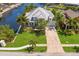 Stunning waterfront home with lush landscaping, metal roof, and a long driveway leading to an attached garage at 708 Islebay Dr, Apollo Beach, FL 33572