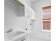 Bright laundry room with ample cabinetry, a utility sink, and a window providing natural light at 708 Islebay Dr, Apollo Beach, FL 33572