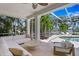 Enclosed patio features comfortable seating, elegant columns, a ceiling fan, and scenic pool views at 708 Islebay Dr, Apollo Beach, FL 33572