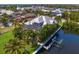 A rear exterior view of a home with a screened lanai, mature palm trees, and a private dock on the canal at 708 Islebay Dr, Apollo Beach, FL 33572