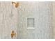 Modern shower featuring designer tiling, gold fixtures, and a built-in niche for toiletries at 708 Islebay Dr, Apollo Beach, FL 33572