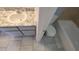 Tiled bathroom features a marble countertop vanity, toilet, and a well lit shower tub combination at 7502 Bolanos Ct, Tampa, FL 33615