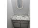 Small bathroom sink and vanity with marble-look countertop and a decorative oval mirror at 7502 Bolanos Ct, Tampa, FL 33615