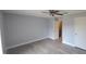 A neutral bedroom with wood-look flooring, closet and open bathroom entrance at 7502 Bolanos Ct, Tampa, FL 33615