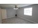 Well-lit bedroom boasts tile flooring, a ceiling fan, and a large bright window at 7502 Bolanos Ct, Tampa, FL 33615