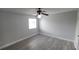 A well-lit bedroom featuring a ceiling fan, wood-look flooring and a window at 7502 Bolanos Ct, Tampa, FL 33615