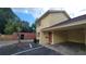 Exterior view of a condo with yellow stucco, brown trim and a covered parking area at 7502 Bolanos Ct, Tampa, FL 33615