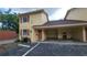 Yellow exterior of the condo building with a carport, dark trim, and clearly marked unit numbers at 7502 Bolanos Ct, Tampa, FL 33615