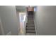 Hallway with tiled floors and gray walls leads to living area and stairs to the upper level at 7502 Bolanos Ct, Tampa, FL 33615