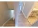 A gray-toned staircase with wood-look flooring leads to a bathroom with a patterned tile floor at 7502 Bolanos Ct, Tampa, FL 33615