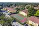 Aerial view showcasing the tennis court and yellow apartment buildings within the community at 7512 Dolonita Dr # 7512, Tampa, FL 33615