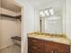 Bathroom with granite countertop, sink, large mirror, and walk-in closet, offering both style and functionality at 7512 Dolonita Dr # 7512, Tampa, FL 33615