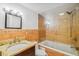 Bathroom with a luxurious glass-enclosed tub and shower, complemented by warm toned tiling and a granite vanity at 7512 Dolonita Dr # 7512, Tampa, FL 33615