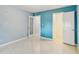 Bedroom featuring tiled floor, blue walls, and white trim, with view into additional rooms at 7512 Dolonita Dr # 7512, Tampa, FL 33615