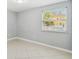 A bright bedroom featuring light gray walls, tile floor, and a sunny window with blinds at 7512 Dolonita Dr # 7512, Tampa, FL 33615