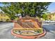 Community sign for 'The Greens of Town 'n' Country Condominium' with surrounding landscaping at 7512 Dolonita Dr # 7512, Tampa, FL 33615