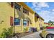 Condo with yellow siding, dark red shutters, and a well-kept lawn on a sunny day at 7512 Dolonita Dr # 7512, Tampa, FL 33615