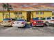 Condominium building with yellow facade, red shutters, parking spaces, and beautiful sunset clouds at 7512 Dolonita Dr # 7512, Tampa, FL 33615