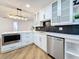 Well-appointed kitchen featuring white cabinetry, stainless steel appliances, and modern lighting at 7711 Dover N Ct, St Petersburg, FL 33709