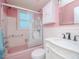 Pink themed bathroom featuring a tub, vanity, sink and medicine cabinet at 7755 39Th N Ave, St Petersburg, FL 33709