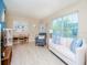 Bright living room with a white sofa, accent chair, and natural light from the large window at 7755 39Th N Ave, St Petersburg, FL 33709
