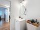 Bathroom featuring a white vanity and toilet, wood-look floors, and an oval mirror at 777 62Nd N Ave, St Petersburg, FL 33702