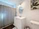 Bright bathroom featuring a white vanity, oval mirror, and shower with neutral-toned curtain at 777 62Nd N Ave, St Petersburg, FL 33702