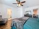Spacious bedroom with wood-look floors and a ceiling fan leading to a bathroom and living room at 777 62Nd N Ave, St Petersburg, FL 33702