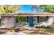 Charming single-story home features a manicured front yard and an inviting blue front door at 777 62Nd N Ave, St Petersburg, FL 33702