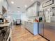 Spacious kitchen featuring stainless steel refrigerator, granite countertops, gray cabinets, and wood flooring at 777 62Nd N Ave, St Petersburg, FL 33702