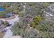 An aerial shot presents a property near a lake, enveloped by mature trees and neighboring residential homes at 8740 Forest Lake Dr, Port Richey, FL 34668