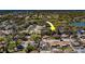 Drone shot pointing to a property in a verdant residential area, adjacent to a tranquil lake, highlighting its desirable location at 8740 Forest Lake Dr, Port Richey, FL 34668