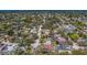 Bird's eye view of a neighborhood featuring homes with lush landscaping, interspersed with mature trees and a serene lake at 8740 Forest Lake Dr, Port Richey, FL 34668