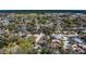 Aerial view of a neighborhood showcasing a mix of homes with mature trees and green spaces at 8740 Forest Lake Dr, Port Richey, FL 34668