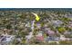 Overhead view of a home in a tree-lined street, marked by a yellow arrow, with neighborhood and lake visible nearby at 8740 Forest Lake Dr, Port Richey, FL 34668