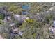 Aerial view of a residential area with tree coverage and a small pond at 8740 Forest Lake Dr, Port Richey, FL 34668