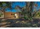 Back exterior view with a small patio and some lawn furniture visible through the trees at 8740 Forest Lake Dr, Port Richey, FL 34668