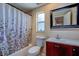 Bright bathroom featuring a shower-tub combo, modern vanity, and stylish mirror at 8740 Forest Lake Dr, Port Richey, FL 34668