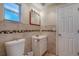 Bathroom features a vanity, decorative tile accent and a toilet at 8740 Forest Lake Dr, Port Richey, FL 34668