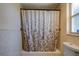 Bathroom featuring tiled walls and shower-tub combo with a decorative curtain at 8740 Forest Lake Dr, Port Richey, FL 34668