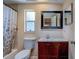 Bathroom featuring a shower-tub combo, modern vanity, and framed mirror at 8740 Forest Lake Dr, Port Richey, FL 34668