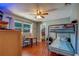 Bedroom with wooden floors, ceiling fan, bunk beds, and a wardrobe area at 8740 Forest Lake Dr, Port Richey, FL 34668