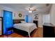 A cozy bedroom features hardwood floors, a comfortable bed, and natural light from the windows at 8740 Forest Lake Dr, Port Richey, FL 34668